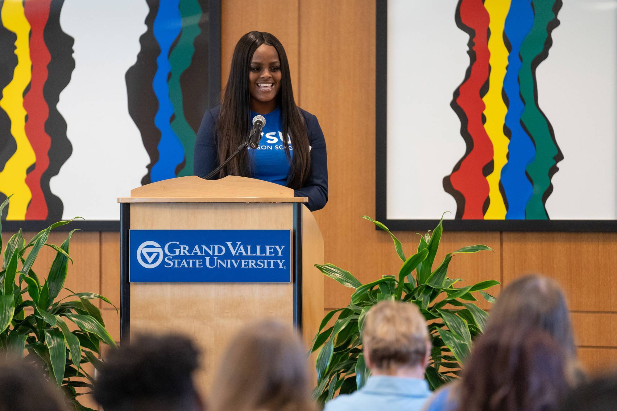 Domonique Palmer addresses a GVSU audience from a lecturn